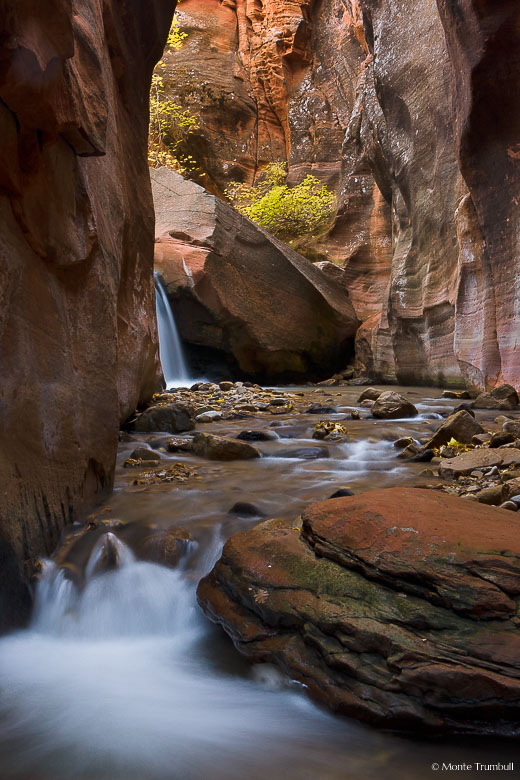 Kanarra Creek flows over a waterfall and into a rock canyon outside of Kanarraville, Utah.