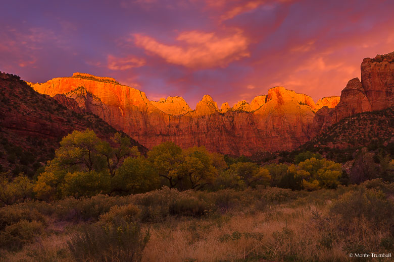 Stormy skies break and the scene is painted red at sunrise at the Towers of the Virgin in Zion National Park, Utah.