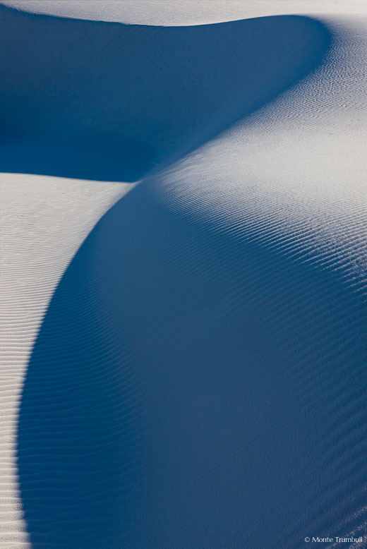 Light playing off of sand dunes and the shadows that are cast create an interesting curving pattern in White Sands National Monument, New Mexico.