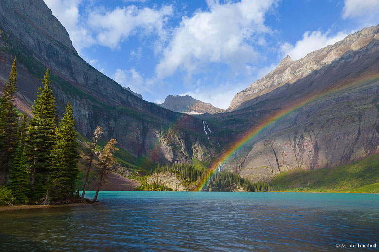 A rainbow appears as the sun breaks through the clouds during a morning shower at Grinnell Lake in Glacier National Park in Montana.