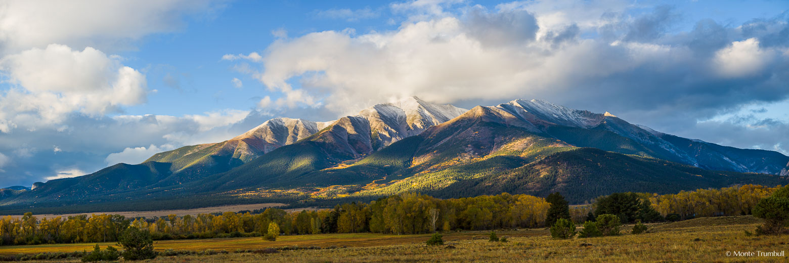 Overnight storm clouds begin to clear shortly after sunrise revealing a dusting of snow on the top of Mt. Princeton outside of Buena Vista, Colorado.