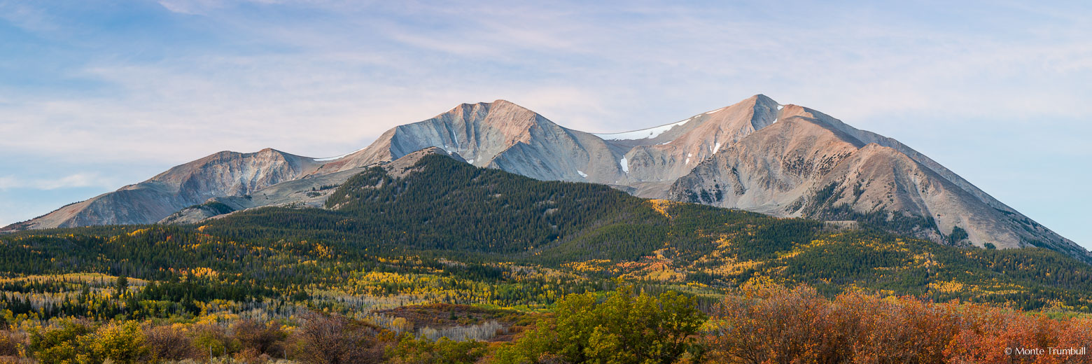 Mount Sopris catches the first light of dawn through a veil of high clouds that create a peaceful feeling over the autumn scene outside of Carbondale, Colorado.